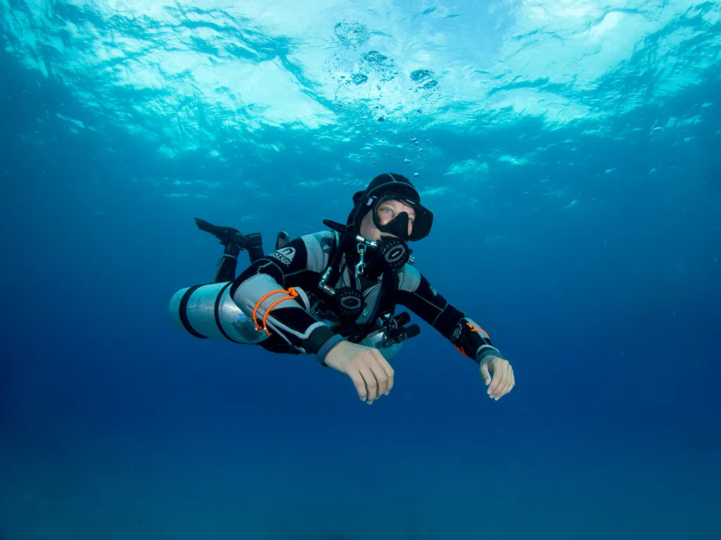 Sidemount diver hovering in open blue water